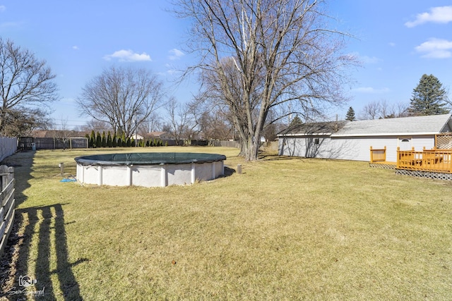 view of yard with a deck and a covered pool