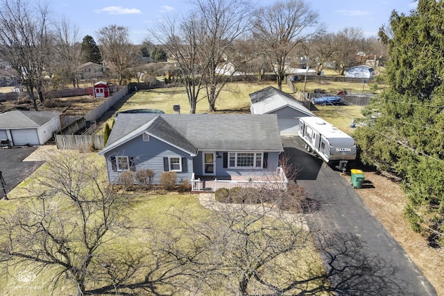 view of front facade featuring asphalt driveway, a porch, fence, and a garage