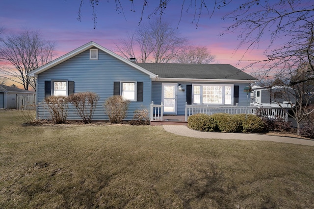 ranch-style home with covered porch and a lawn