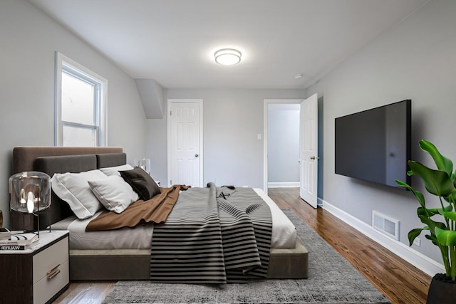 bedroom with wood finished floors and baseboards