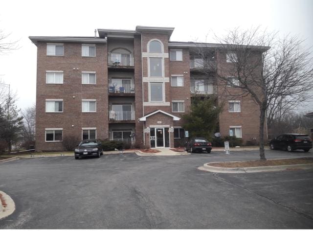 view of apartment building / complex with uncovered parking