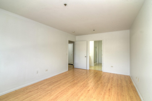 empty room featuring light wood-style flooring and baseboards