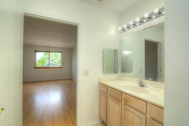 bathroom featuring wood finished floors, baseboards, and vanity