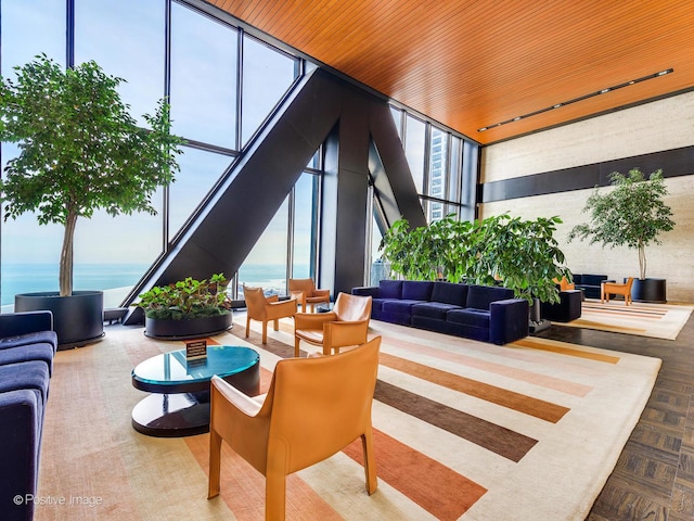 community lobby featuring expansive windows, a water view, and a towering ceiling