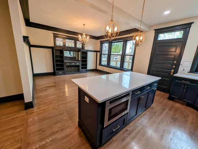 7411 S Champlain Ave, Chicago, IL 60619 - kitchen featuring a chandelier, light countertops, stainless steel microwave, light wood-type flooring, and recessed lighting