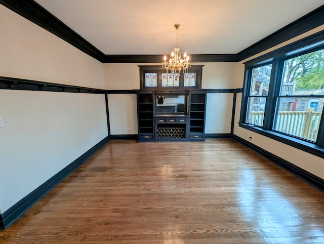 7411 S Champlain Ave, Chicago, IL 60619 - unfurnished dining area featuring a chandelier, ornamental molding, baseboards, and wood finished floors