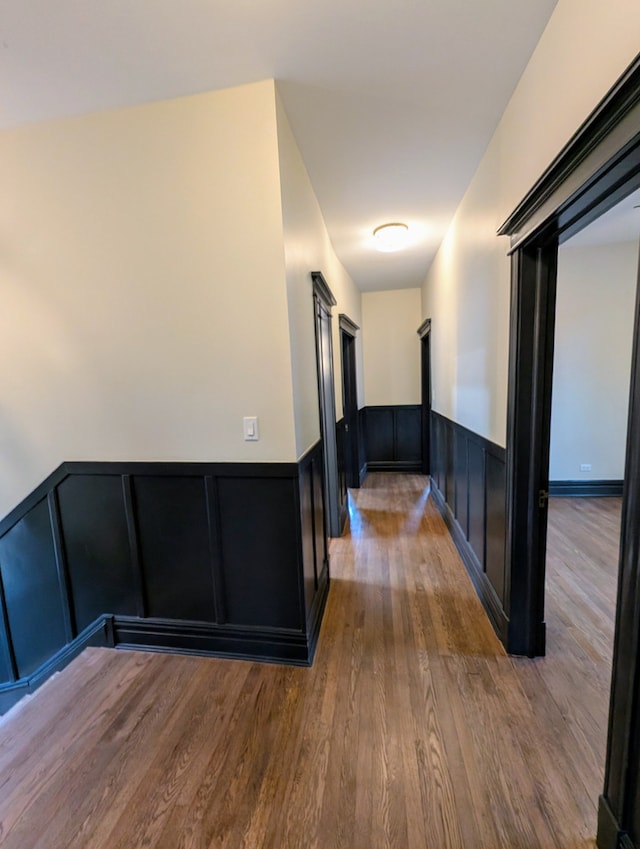 7411 S Champlain Ave, Chicago, IL 60619 - hall with wainscoting, wood finished floors, a decorative wall, and an upstairs landing