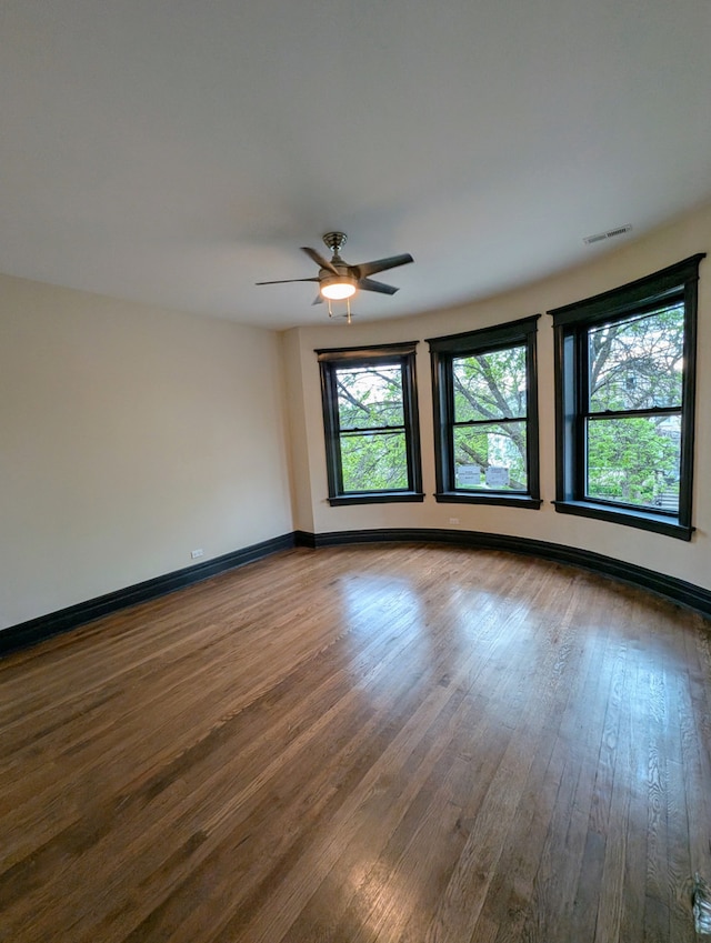7411 S Champlain Ave, Chicago, IL 60619 - unfurnished room featuring dark wood-style flooring, baseboards, and a ceiling fan