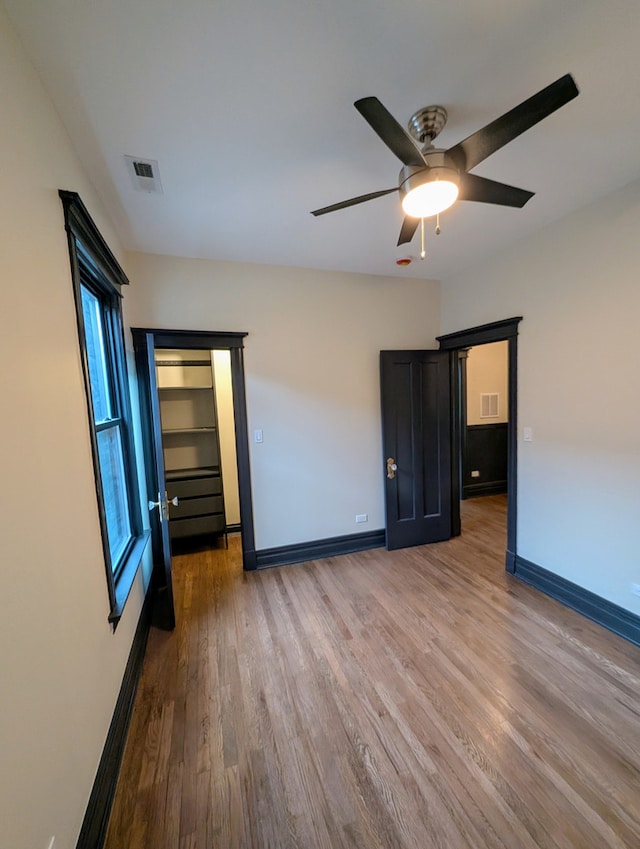 7411 S Champlain Ave, Chicago, IL 60619 - unfurnished bedroom with wood finished floors, baseboards, and ceiling fan