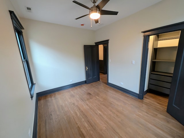 7411 S Champlain Ave, Chicago, IL 60619 - unfurnished bedroom with light wood-style flooring, baseboards, and ceiling fan
