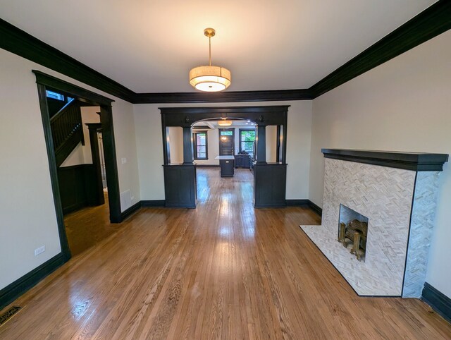 7411 S Champlain Ave, Chicago, IL 60619 - unfurnished dining area featuring arched walkways, wood finished floors, baseboards, crown molding, and a fireplace with flush hearth