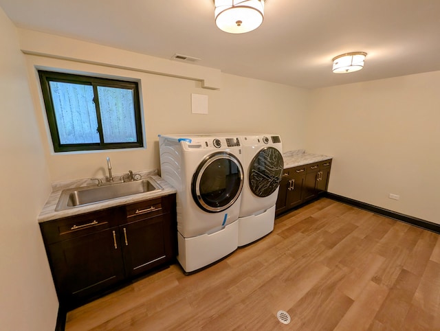 7411 S Champlain Ave, Chicago, IL 60619 - laundry room with washing machine and dryer, cabinet space, light wood-style flooring, and baseboards