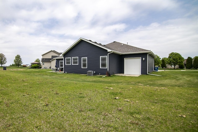 back of house featuring an attached garage and a yard