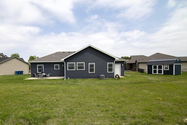 back of house with a shed, a yard, an outbuilding, a patio, and central AC
