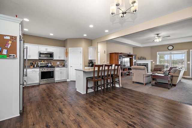 kitchen featuring stainless steel appliances, open floor plan, recessed lighting, white cabinetry, and a chandelier