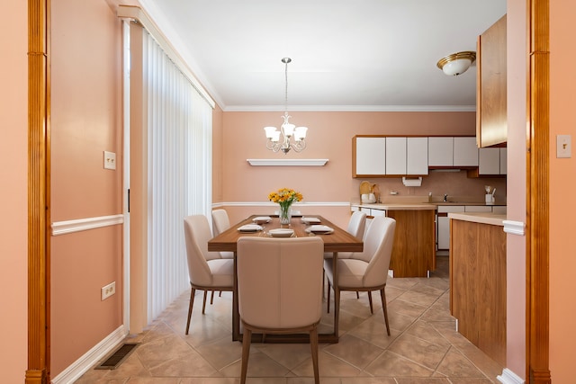 dining space with a chandelier, ornamental molding, and light tile patterned floors