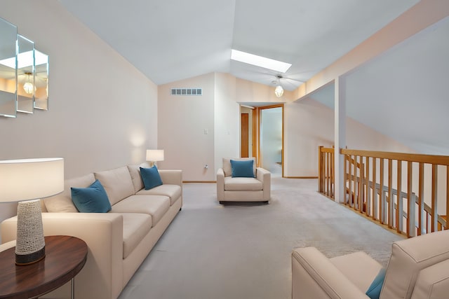living room with vaulted ceiling, a skylight, light colored carpet, and baseboards