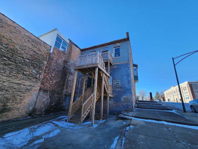 rear view of house featuring stairway and a wooden deck