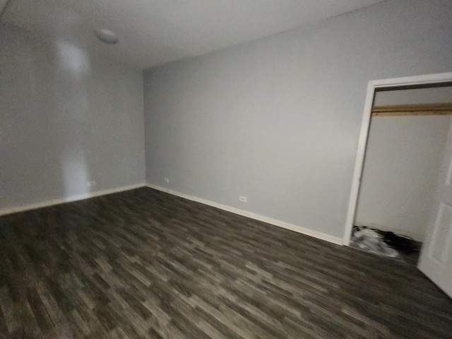 unfurnished bedroom with dark wood-style flooring and baseboards