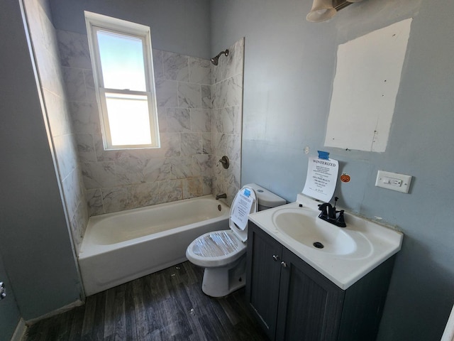 bathroom with wood finished floors, toilet, bathing tub / shower combination, and vanity
