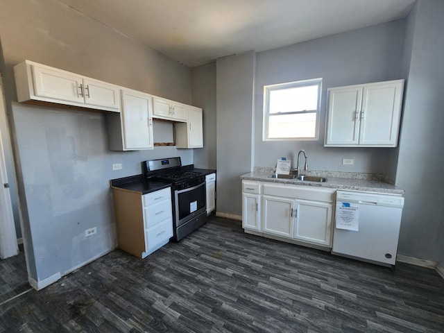 kitchen featuring gas range, a sink, white dishwasher, dark wood-style floors, and baseboards