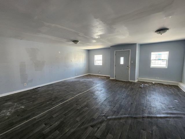foyer entrance featuring dark wood finished floors and baseboards