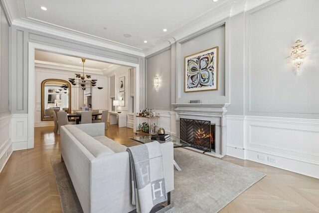1855 N Hermitage Ave, Chicago, IL 60622 - living room with a decorative wall, a chandelier, ornamental molding, and a warm lit fireplace