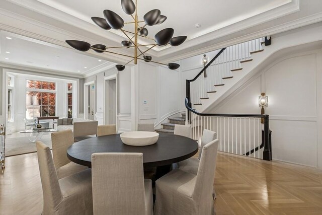 1855 N Hermitage Ave, Chicago, IL 60622 - dining room with a decorative wall, crown molding, a chandelier, stairs, and a tray ceiling