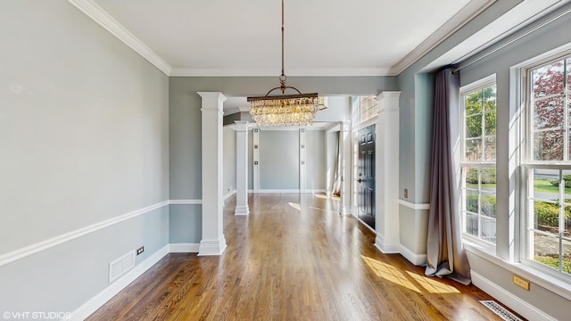 8 Georgetown Ct, Algonquin, IL 60102 - unfurnished dining area featuring a chandelier, decorative columns, wood finished floors, baseboards, and crown molding