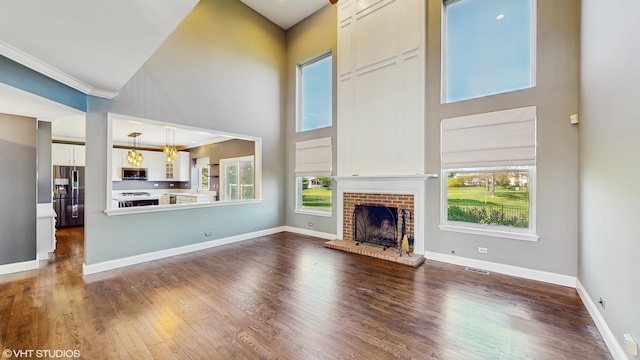 8 Georgetown Ct, Algonquin, IL 60102 - unfurnished living room with a towering ceiling, a brick fireplace, dark wood-type flooring, and baseboards
