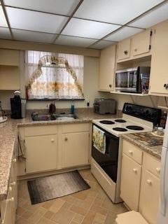 75 6th Ave Unit 209, La Grange, IL 60525 - kitchen featuring range with electric cooktop, stainless steel microwave, a sink, light countertops, and a paneled ceiling