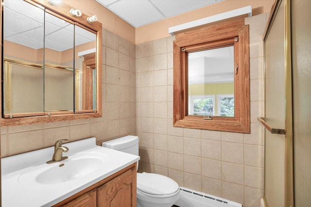 2109 Grange Dr, Urbana, IL 61801 - bathroom with baseboard heating, tile walls, vanity, and a shower with shower door