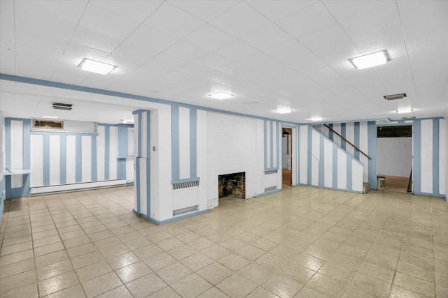 2109 Grange Dr, Urbana, IL 61801 - finished below grade area with a baseboard heating unit, a brick fireplace, and wallpapered walls