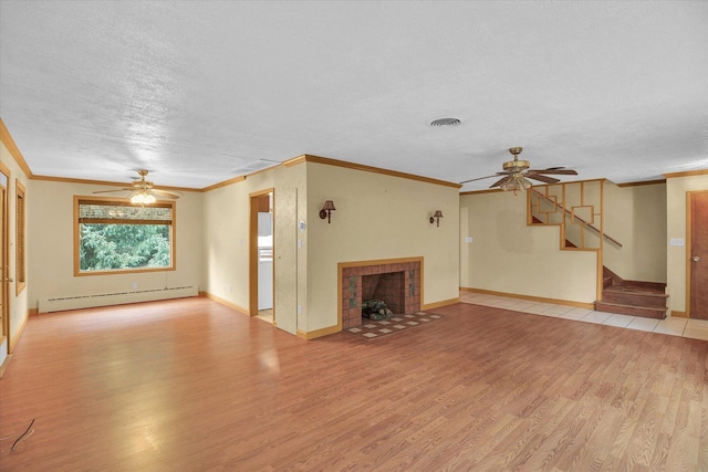 2109 Grange Dr, Urbana, IL 61801 - unfurnished living room with a ceiling fan, a baseboard heating unit, light wood-style floors, a tile fireplace, and stairs
