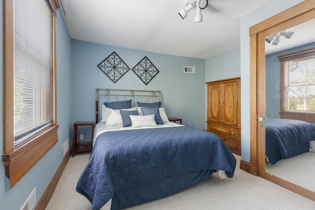 bedroom with light carpet and baseboards