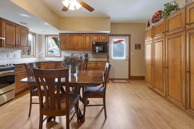 dining space featuring light wood finished floors, a ceiling fan, and recessed lighting