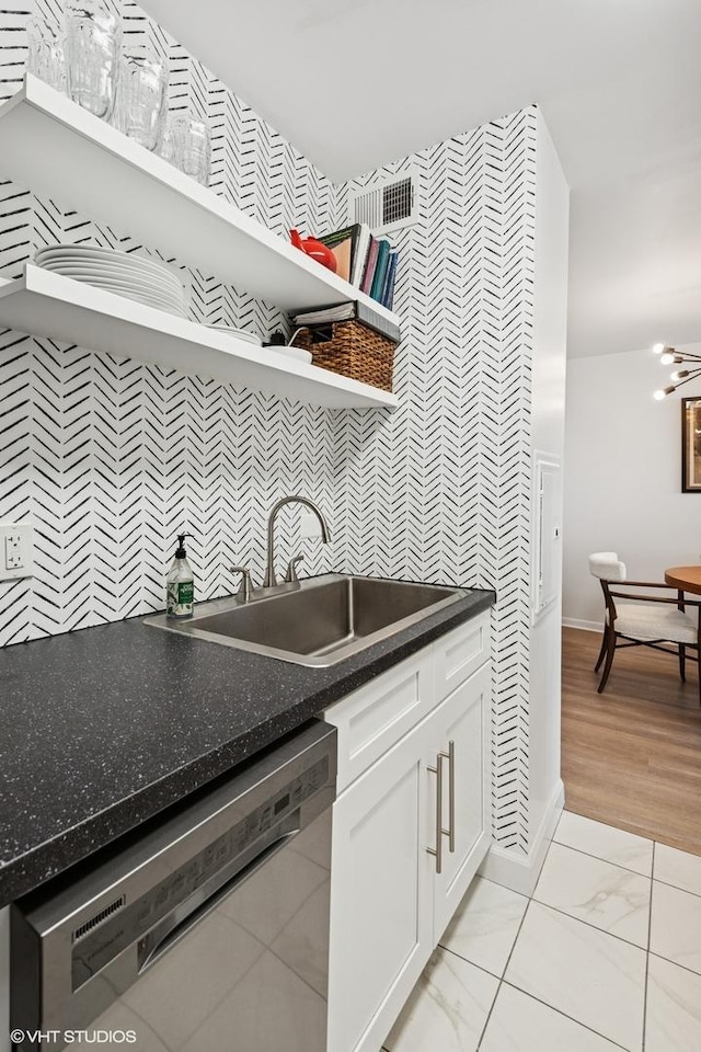6171 N Sheridan Rd Unit 2704, Chicago, IL 60660 - laundry area featuring wallpapered walls, a sink, baseboards, an accent wall, and a chandelier