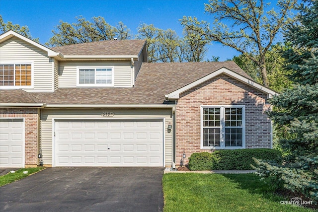 view of front of property featuring asphalt driveway, brick siding, and roof with shingles