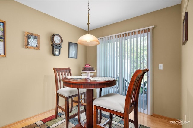 dining space with baseboards and light wood-type flooring