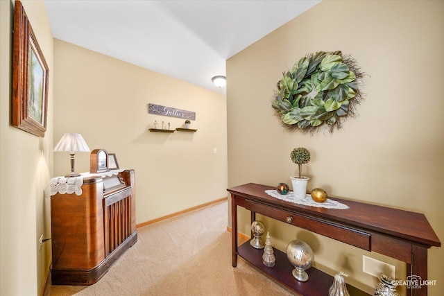 hallway with carpet floors and baseboards