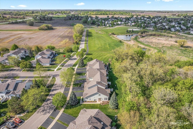 aerial view of property and surrounding area with nearby suburban area and a large body of water