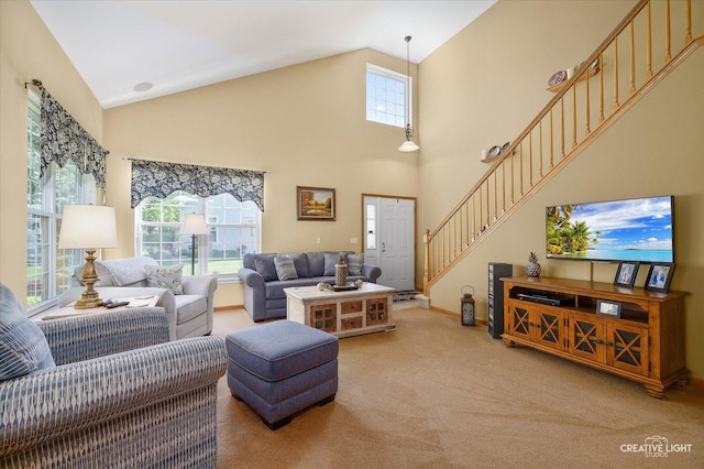 living room featuring light carpet, plenty of natural light, high vaulted ceiling, stairway, and baseboards