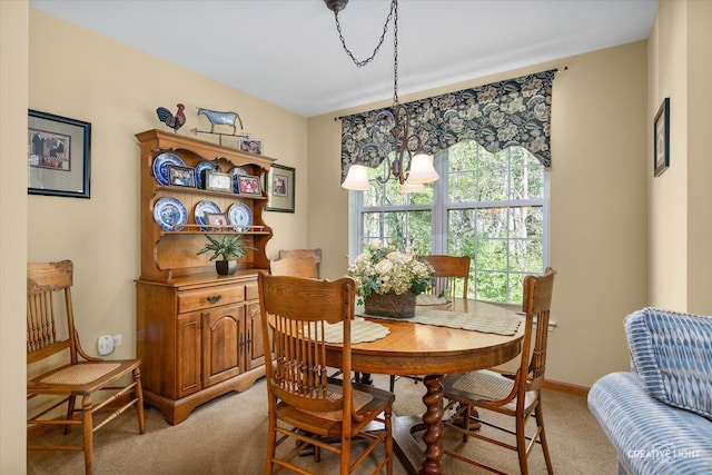 dining area featuring light carpet and baseboards