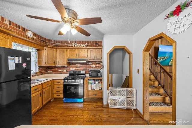 1020 Hahn Pl, West Chicago, IL 60185 - kitchen with black appliances, a sink, under cabinet range hood, a textured ceiling, and dark wood-type flooring