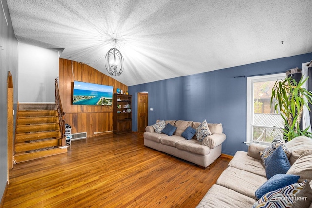 1020 Hahn Pl, West Chicago, IL 60185 - living room featuring wood finished floors, vaulted ceiling, a chandelier, a textured ceiling, and stairs
