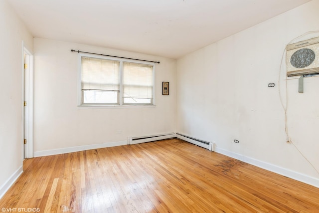 empty room with light wood-style flooring, baseboards, and a baseboard radiator