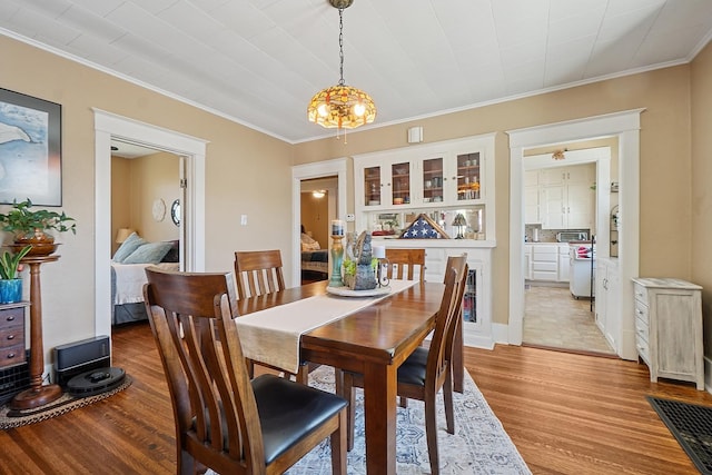 1009 W Madison St, Ottawa, IL 61350 - dining area with light wood-style flooring, crown molding, and a chandelier