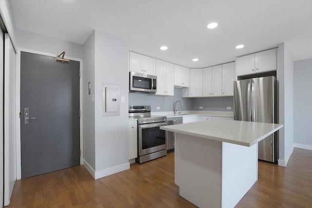 kitchen featuring stainless steel appliances, light countertops, baseboards, white cabinets, and a center island
