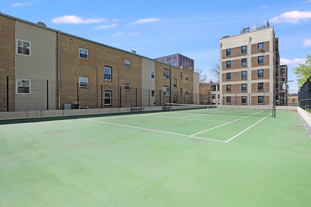 view of tennis court with fence and community basketball court