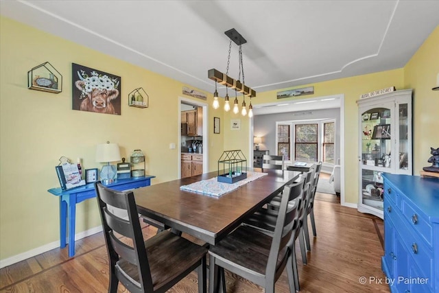 dining room featuring dark wood finished floors and baseboards